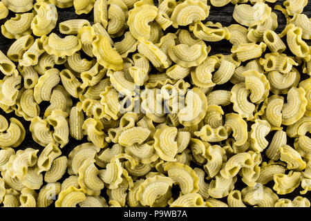 Pasta spinach creste di gallo raw top view isolated on black wood background flatlay Stock Photo