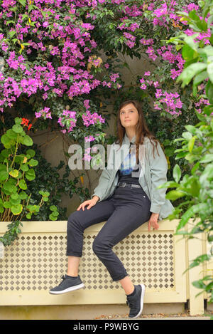 Teen girl smell  bougainvillea flowers in botanical garden Stock Photo