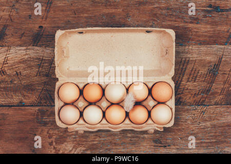 the eggs in the carton boxes laying on wooden retro top view closeup Stock Photo