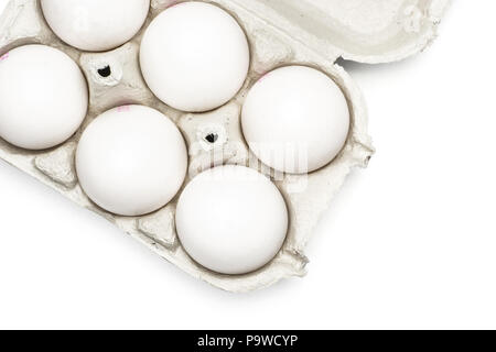 Six white chicken eggs in a paper grey crate top view isolated on white background Stock Photo