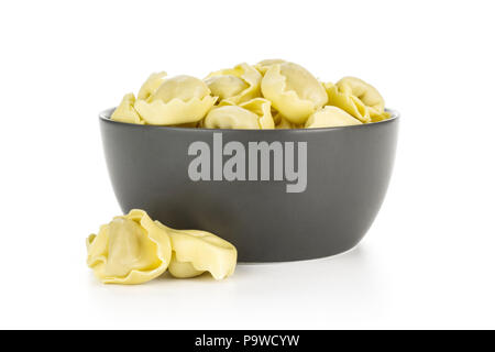 Raw Italian tortellini pasta in a grey ceramic bowl isolated on white background traditional dumplings Stock Photo