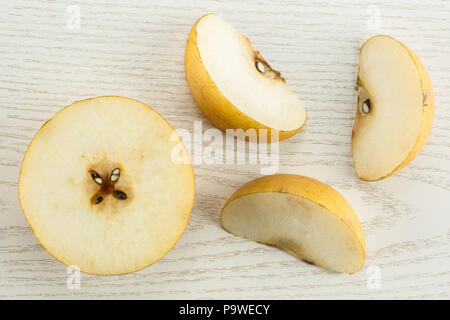 Chinese golden pears top view Nashi variety isolated on white wooden background one half three slices Stock Photo