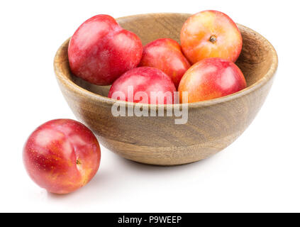 Plums red orange in a wood bowl isolated on white background Stock Photo