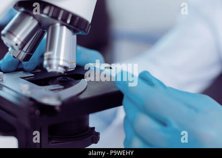 Biological analysis. Close up of a microscope slide with a test sample on it while being ready for biological analysis Stock Photo