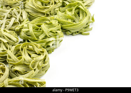 Raw spinach fettuccine pasta background isolated on white Stock Photo