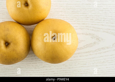Chinese golden pears top view Nashi variety isolated on white wooden background three whole round Stock Photo