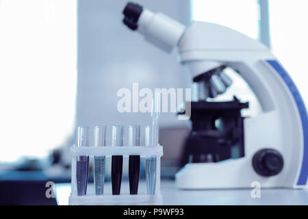 Samples for analysis. Test tubes with different liquids standing in the rack while being ready for biological analysis Stock Photo