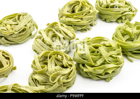 Spinach fettuccine raw pasta background isolated on white Stock Photo