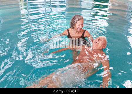 Senior couple having fun together at the aqua fitness in the pool Stock Photo
