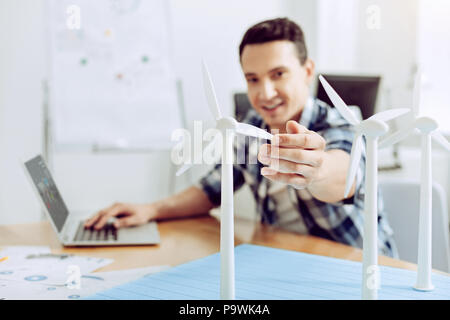 Successful engineer. Qualified successful cheerful engineer looking glad while working in his office Stock Photo