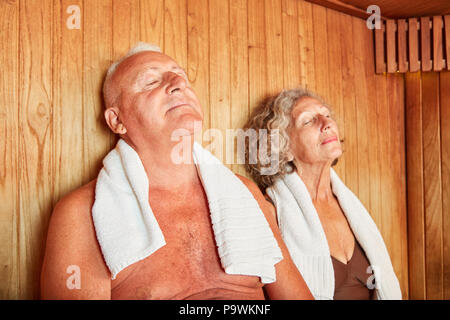 Relaxed senior couple enjoying the healthy heat in the wellness sauna Stock Photo