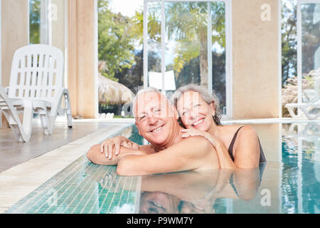 Smiling senior couple at the poolside in the swimming pool at the Wellness Hotel Stock Photo
