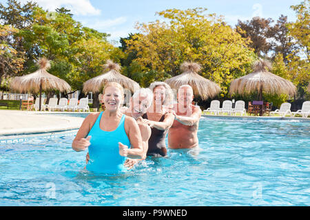 Cheerful seniors group has fun together in the pool of the wellness hotel Stock Photo