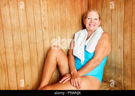 Smiling senior woman relaxing in the sauna on a spa vacation Stock Photo