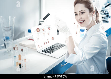 Nice smart scientist sitting in front of the laptop Stock Photo