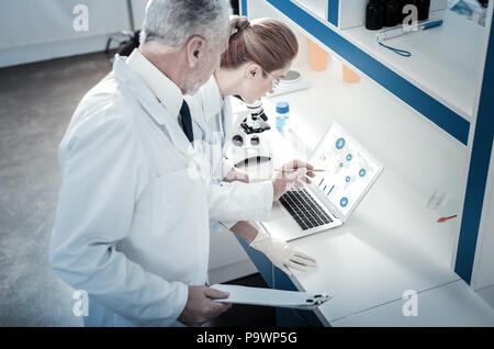 Serious male scientist holding a pencil Stock Photo