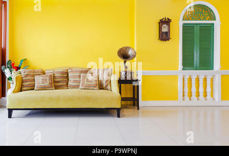 yellow sofa, Ancient Turntables with Green window on yellow wall. Stock Photo