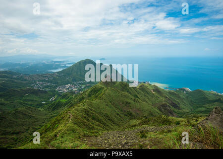 A view from the summit of the Teapot Mountain trail, with the 'Teapot' peak in the middle of the image, and ocean and sky in the background. Taiwan. Stock Photo