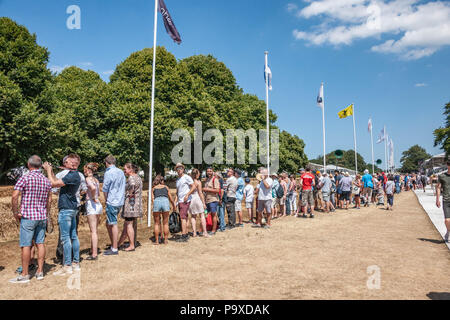 Spectators stand watching cars race on the famous circuit at Goodwood, during the Festival of Speed's 25th, Jubilee anniversary. Stock Photo