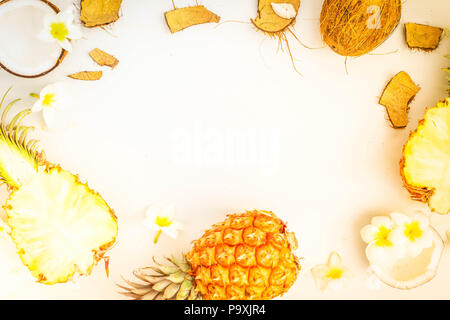 Summer flat lay scene with exotic tropical fruits pineapples and coconuts on gray wooden background, retro toned Stock Photo