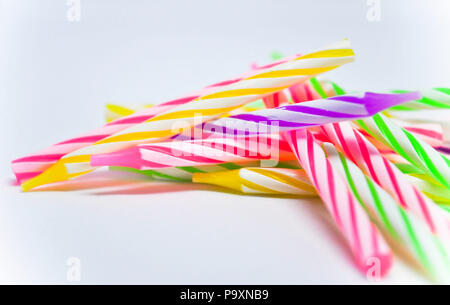 A selection of multicoloured, striped birthday candles which would be used on a birthday cake. They are set against a white background Stock Photo