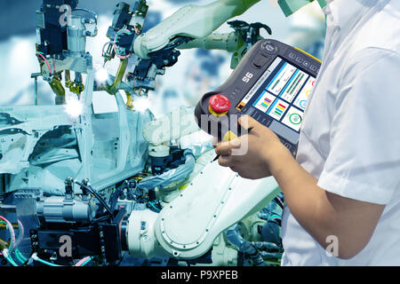 iot smart factory , industry 4.0 technology concept, Engineer use controller robot in automation factory background with fake sunlight on operation li Stock Photo