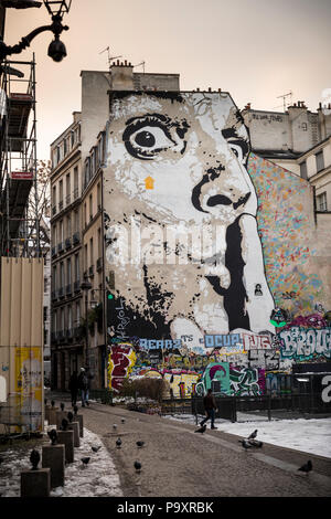 Mural of human face with finger on lips on wall of apartment block, The Marais, Paris Stock Photo