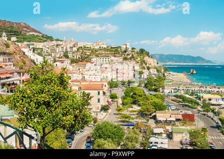view of small city on Amalfi coast with ripe mandarin in foreground on sunny day, Vietri Sul Mare, Salerno, Campania, Italy Stock Photo