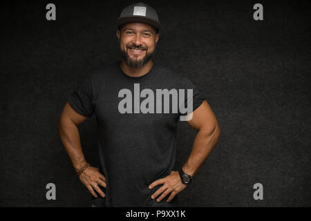 Portrait of Black bearded male in cap over grey background. Stock Photo