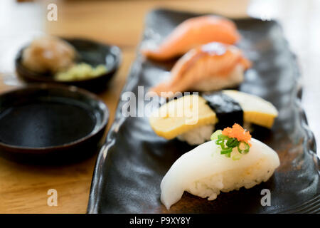 Assorted varieties of sushi platter. Raw fish sushi. Japanese food. Salmon burn, salmon, ika and tamago sushi in Japanese food restaurant. Stock Photo
