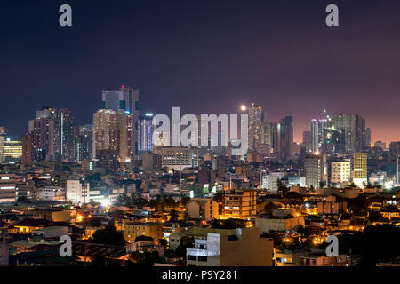 Manila skyline at night with high rise buildings and ordinary residential housing Stock Photo