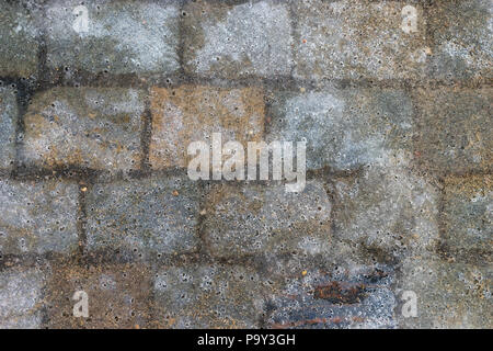Cobbles on the street under a thin layer of ice with sand Stock Photo
