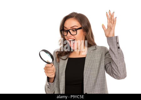Beautiful young happy woman looking trough the magnifying glass Stock Photo