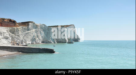 The white chalk cliffs at Seaford Head in East Sussex on the South coast of England with old jetty in the foreground Stock Photo