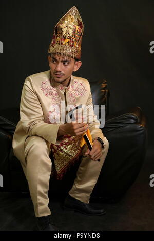 Handsome man in traditional acehnese dress holding Rencong (Traditional aceh weapon) Stock Photo