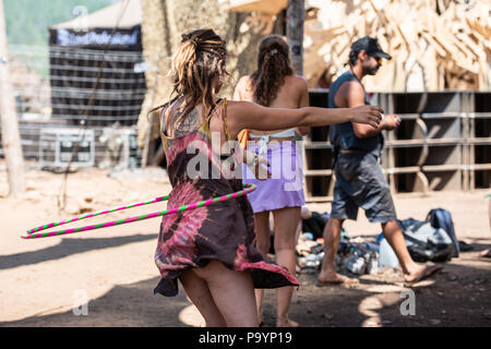 A young woman juggling with a hula hoop while dancing at the Lost Theory psytransce music festival held in Riomalo de Abajo, Las Hurdes, Extremadura, Spain. Stock Photo