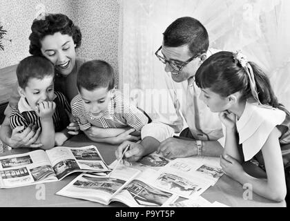 1950s FAMILY OF FIVE READING MAGAZINES BOOKS ON DINING ROOM TABLE - bx017281 CAM001 HARS NOSTALGIC PAIR RELATIONSHIP MOTHERS STUDY OLD TIME NOSTALGIA BROTHER HOMEWORK OLD FASHION SISTER 1 JUVENILE SONS PLEASED FAMILIES JOY FIVE PARENTING FEMALES 5 BROTHERS HUSBANDS HORIZONTAL PLANS DAUGHTERS PERSONS MALES SIBLINGS SISTERS FATHERS HUSBAND AND WIFE B&W HUSBANDS AND WIVES CHEERFUL DADS CAM001 SIBLING SMILES JOYFUL JUVENILES MOMS WIVES BLACK AND WHITE CAUCASIAN ETHNICITY OLD FASHIONED Stock Photo