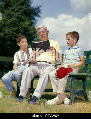 1960s SENIOR MAN GRANDFATHER READING BOOK BIBLE SITTING ON BENCH WITH TWO BOYS GRANDSONS - kr7687 HAR001 HARS RELIGION ELDER GRANDPARENT COPY SPACE FULL-LENGTH PERSONS INSPIRATION CARING MALES SPIRITUALITY CONFIDENCE MIDDLE-AGED MIDDLE-AGED MAN FREEDOM OLDSTERS OLDSTER STRENGTH GRANDSONS DIRECTION AUTHORITY ELDERS CONNECTION GRANDFATHERS GROWTH JUVENILES PRE-TEEN PRE-TEEN BOY TOGETHERNESS CAUCASIAN ETHNICITY GRANDPA HAR001 OLD FASHIONED Stock Photo
