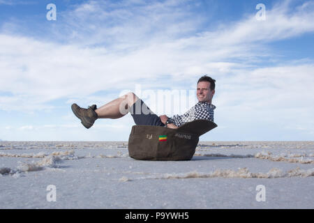 Optical illusion with tourist at Uyuni salt flats / Tourist auf Trickaufnahme im Salar de Uyuni Stock Photo