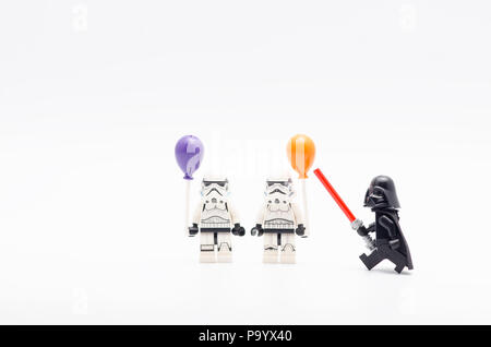 lego  darth vader watching storm troopers holding a balloon. Lego minifigures are manufactured by The Lego Group. Stock Photo