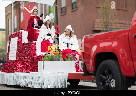Holland, Michigan, USA - May 12, 2018 Beauty queens on a red float, going down the road at the Muziek Parade, during the Tulip Time Festival Stock Photo