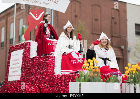 Holland, Michigan, USA - May 12, 2018 Beauty queens on a red float, going down the road at the Muziek Parade, during the Tulip Time Festival Stock Photo