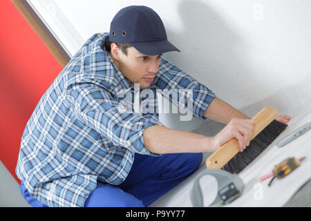 floor tiles installation man installs ceramic tile Stock Photo