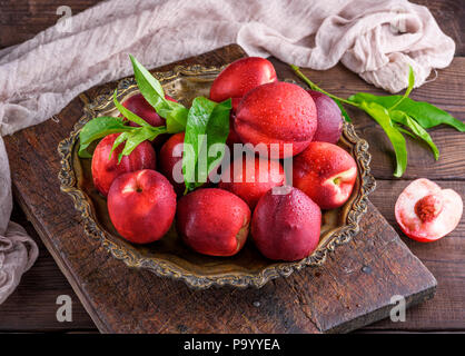 red ripe peaches nectarine in an iron plate, top view Stock Photo