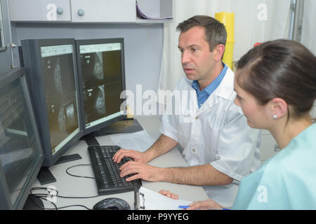 doctors checking xray on a computers screen on a desk Stock Photo