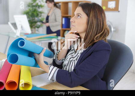 young worried female architect analyzing blueprint in the office Stock Photo