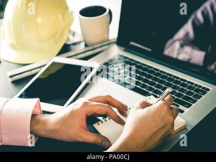 Engineer contractor working on laptop and notebook in office. Stock Photo
