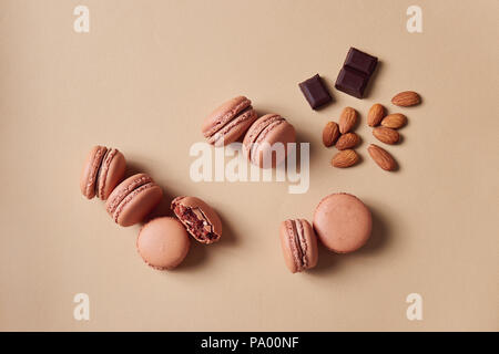 Chocolate macarons (filled macaroon biscuits) with almonds. Stock Photo