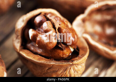 Walnut kernels and whole healthy walnuts on rustic old table Stock Photo