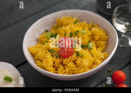 Fusilli pasta with tomatoes and herbs. Delicious Italian dinner. Copy space Stock Photo